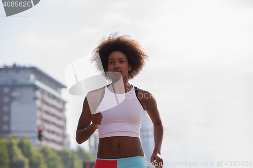 Image of Portrait of sporty young african american woman running outdoors