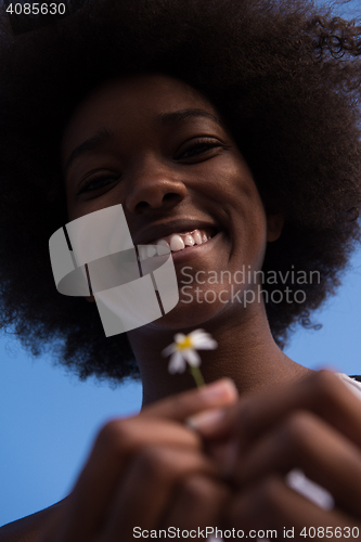 Image of portrait of African American girl with a flower in her hand