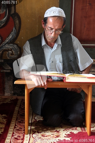 Image of Muslim man reading the Koran in the Aladza painted mosque,Tetovo, Macedonia
