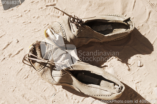 Image of old pair of shoes on sand