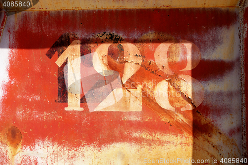 Image of old rusty painted metal wall with numbers