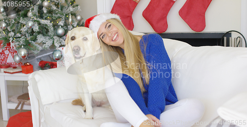 Image of Christmas girl with her dog friend at the couch
