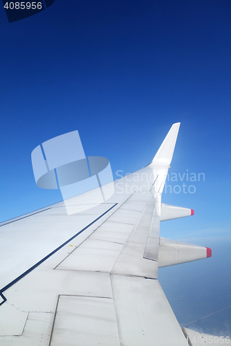 Image of Wing of an airplane on blue sky