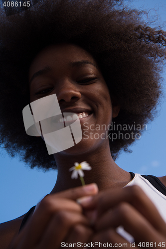 Image of portrait of African American girl with a flower in her hand