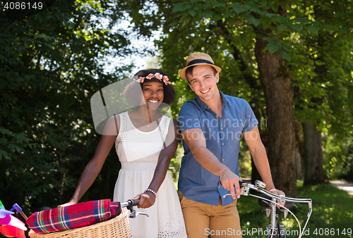 Image of Young multiethnic couple having a bike ride in nature