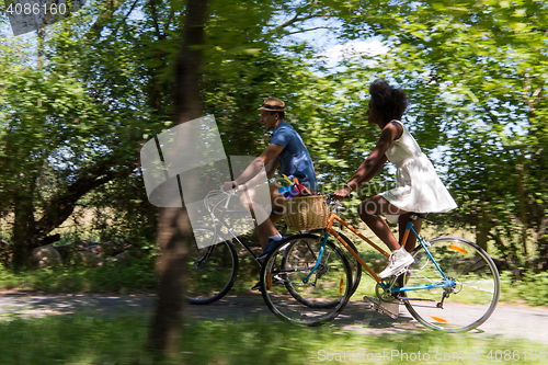 Image of Young multiethnic couple having a bike ride in nature