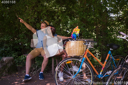 Image of Young multiethnic couple having a bike ride in nature