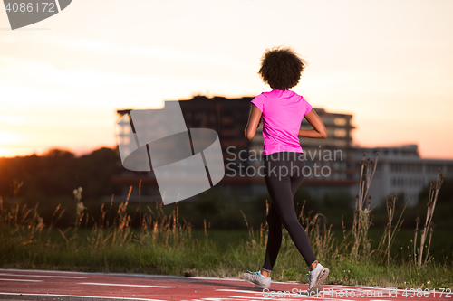 Image of a young African American woman jogging outdoors