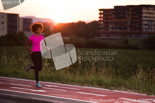 Image of a young African American woman jogging outdoors