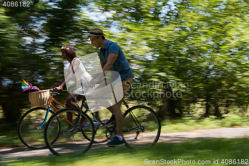 Image of Young multiethnic couple having a bike ride in nature