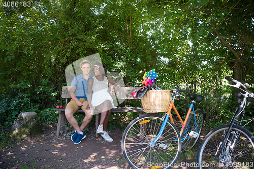 Image of Young multiethnic couple having a bike ride in nature