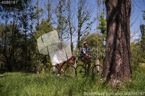 Image of Young multiethnic couple having a bike ride in nature