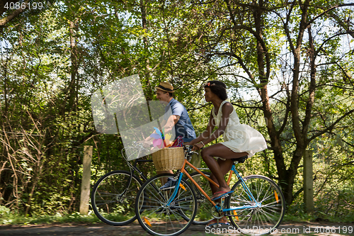 Image of Young multiethnic couple having a bike ride in nature