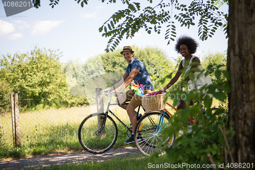 Image of Young multiethnic couple having a bike ride in nature