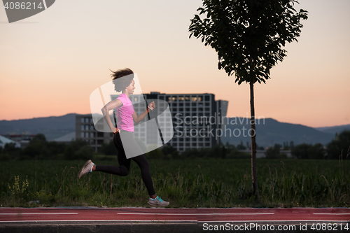 Image of a young African American woman jogging outdoors