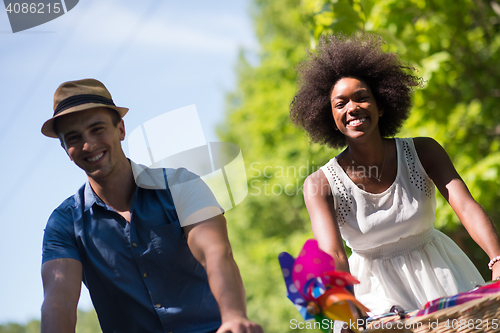 Image of Young multiethnic couple having a bike ride in nature