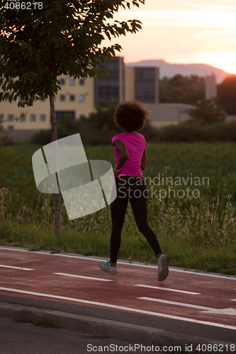 Image of a young African American woman jogging outdoors