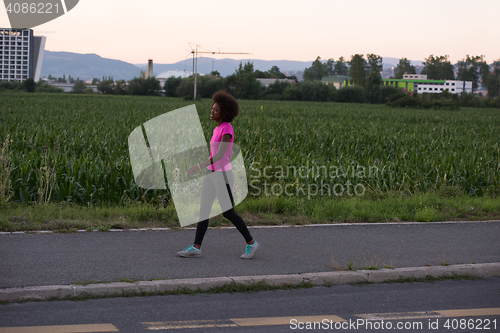 Image of a young African American woman jogging outdoors