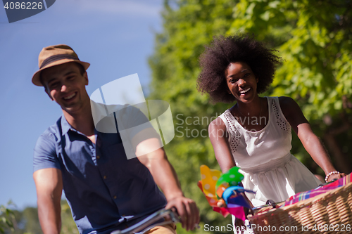 Image of Young multiethnic couple having a bike ride in nature