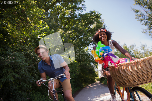 Image of Young multiethnic couple having a bike ride in nature