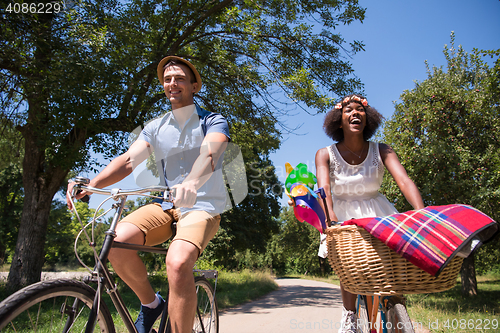 Image of Young multiethnic couple having a bike ride in nature