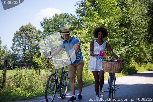 Image of Young multiethnic couple having a bike ride in nature