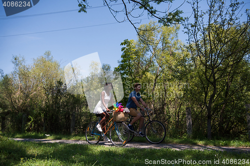 Image of Young multiethnic couple having a bike ride in nature