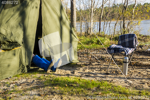 Image of Legs in gumboots sticking out of tent