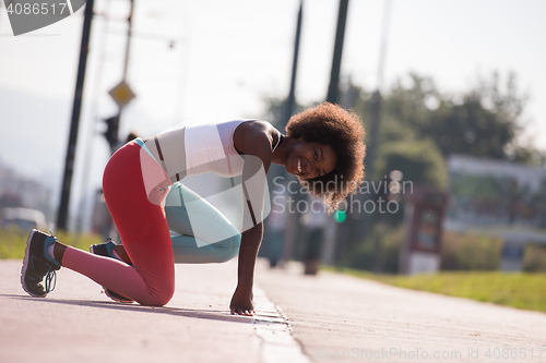 Image of Portrait of sporty young african american woman stretching outdo