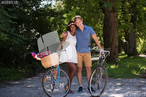 Image of Young multiethnic couple having a bike ride in nature