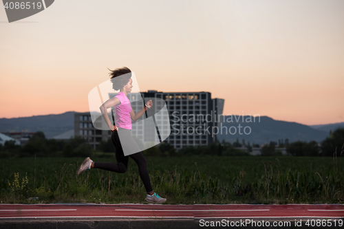 Image of a young African American woman jogging outdoors