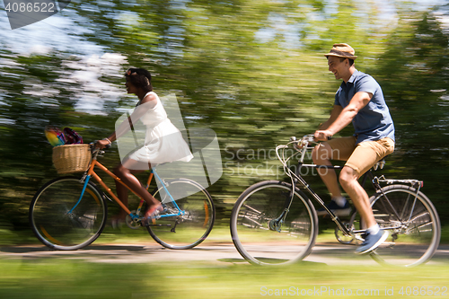 Image of Young multiethnic couple having a bike ride in nature
