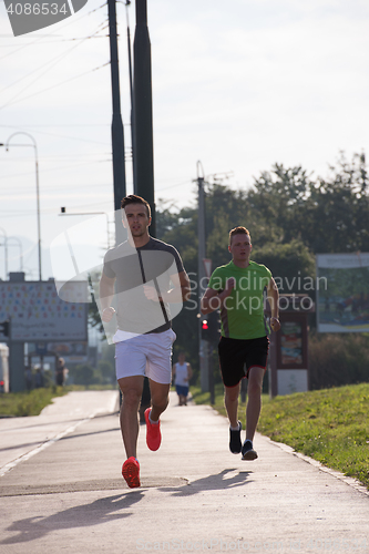 Image of Two young men jogging through the city