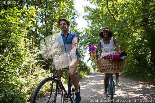 Image of Young multiethnic couple having a bike ride in nature