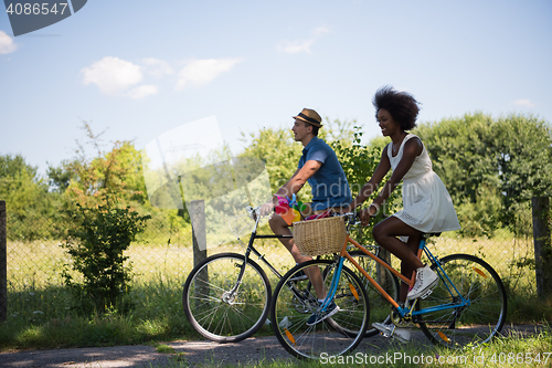 Image of Young multiethnic couple having a bike ride in nature