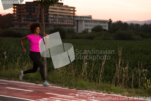 Image of a young African American woman jogging outdoors