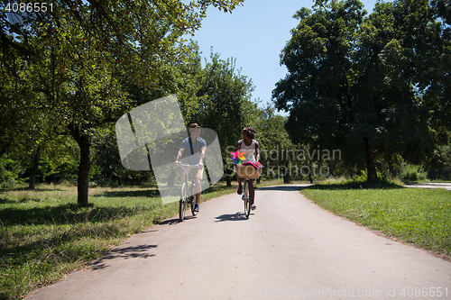 Image of Young multiethnic couple having a bike ride in nature