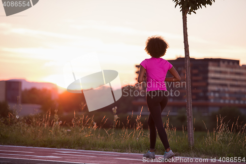 Image of a young African American woman jogging outdoors