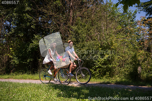 Image of Young multiethnic couple having a bike ride in nature