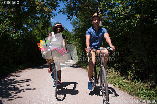 Image of Young multiethnic couple having a bike ride in nature