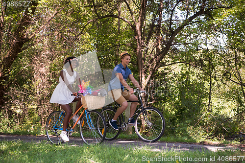 Image of Young multiethnic couple having a bike ride in nature