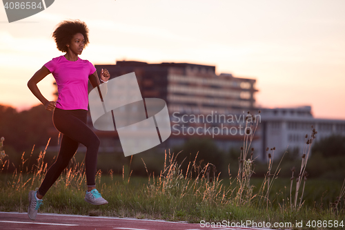 Image of a young African American woman jogging outdoors