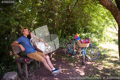 Image of Young multiethnic couple having a bike ride in nature