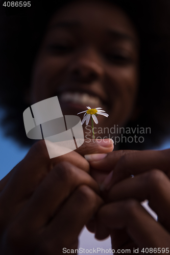 Image of portrait of African American girl with a flower in her hand