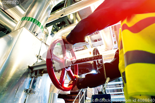 Image of factory worker turning valve