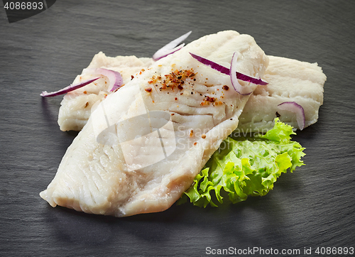 Image of roasted perch fish fillets on black background
