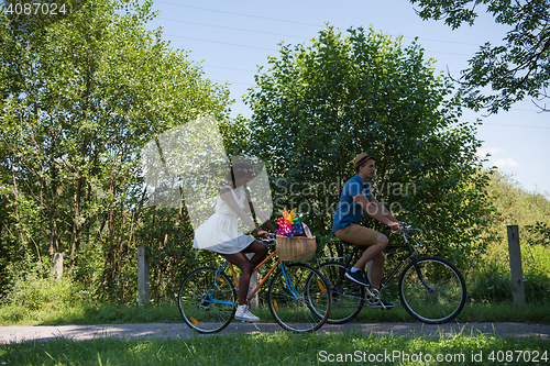 Image of Young multiethnic couple having a bike ride in nature