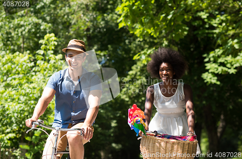 Image of Young multiethnic couple having a bike ride in nature