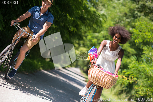 Image of Young multiethnic couple having a bike ride in nature