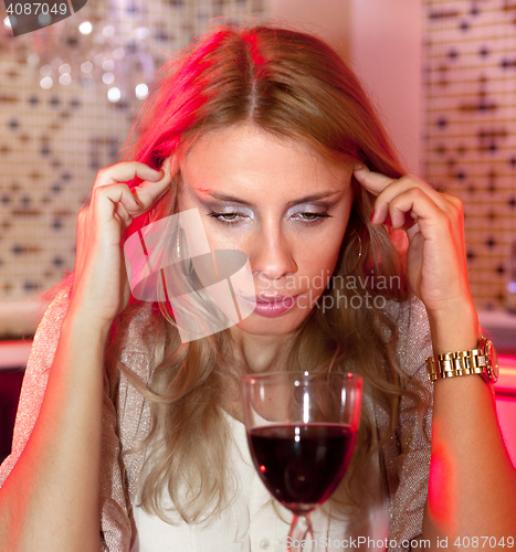 Image of sad woman with glass of red wine